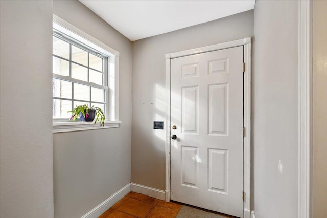 doorway to outside with tile patterned flooring and baseboards