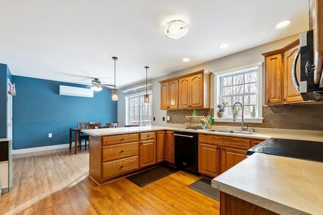 kitchen featuring brown cabinetry, dishwasher, decorative light fixtures, light countertops, and a sink