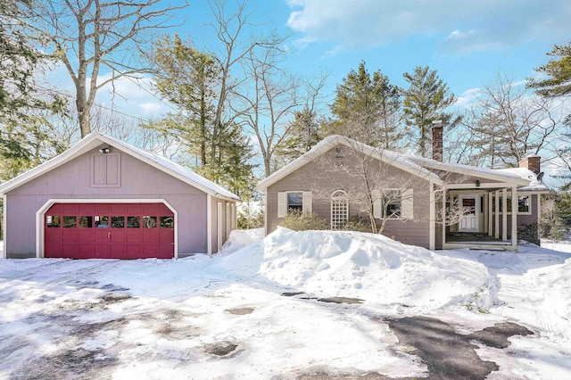 view of front of home featuring a detached garage and a chimney