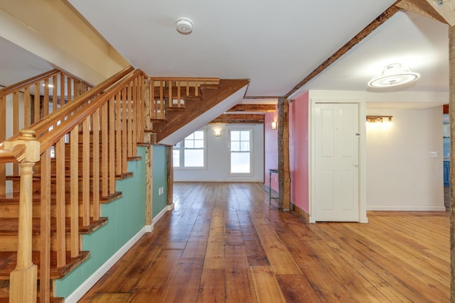 entrance foyer featuring stairway, baseboards, and wood finished floors