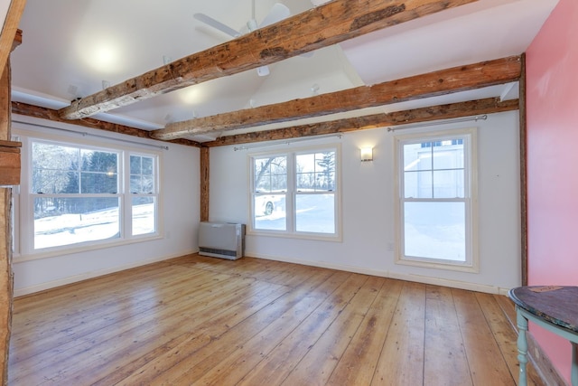 unfurnished room with vaulted ceiling with beams, light wood-style flooring, and baseboards