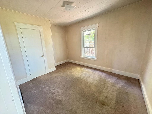 carpeted spare room with baseboards