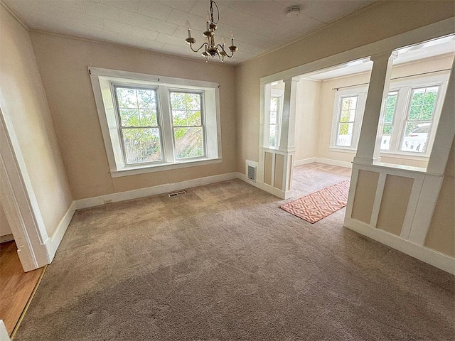 unfurnished room featuring a notable chandelier, carpet, visible vents, and baseboards