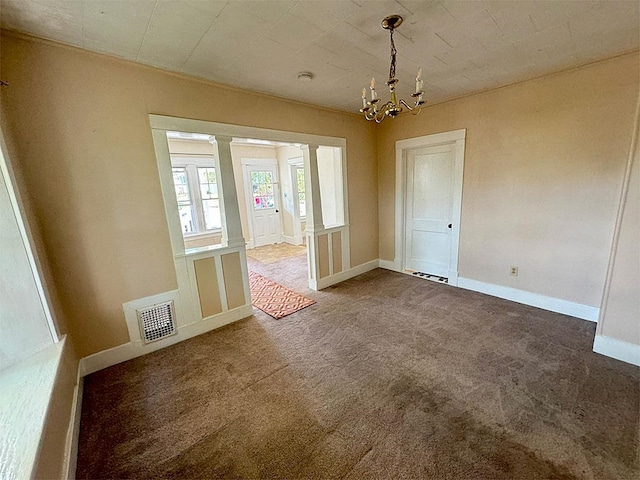 unfurnished dining area with an inviting chandelier, dark carpet, visible vents, and baseboards