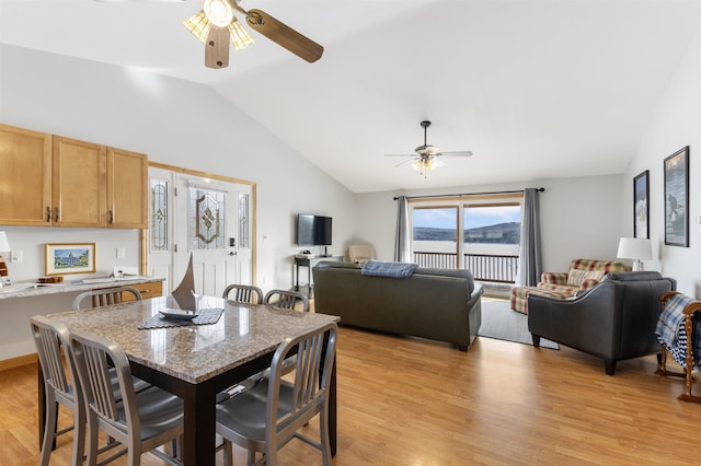 dining space with lofted ceiling, ceiling fan, and light wood-type flooring