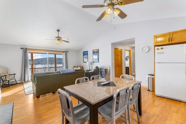 dining room with vaulted ceiling, light wood-type flooring, and a ceiling fan