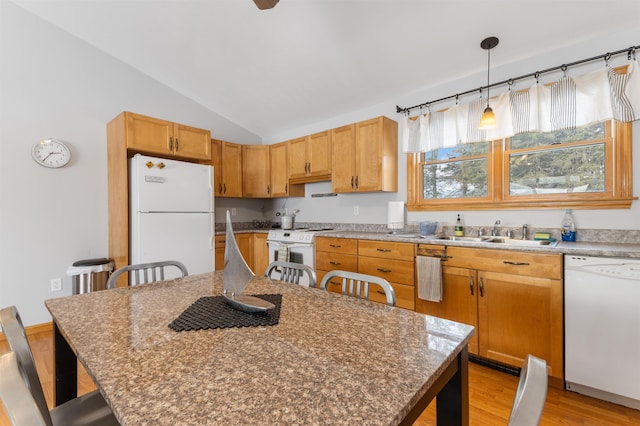 kitchen with white appliances, decorative light fixtures, vaulted ceiling, light wood-style floors, and a sink