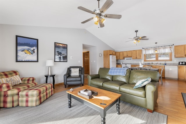 living area with light wood-type flooring, vaulted ceiling, and a ceiling fan