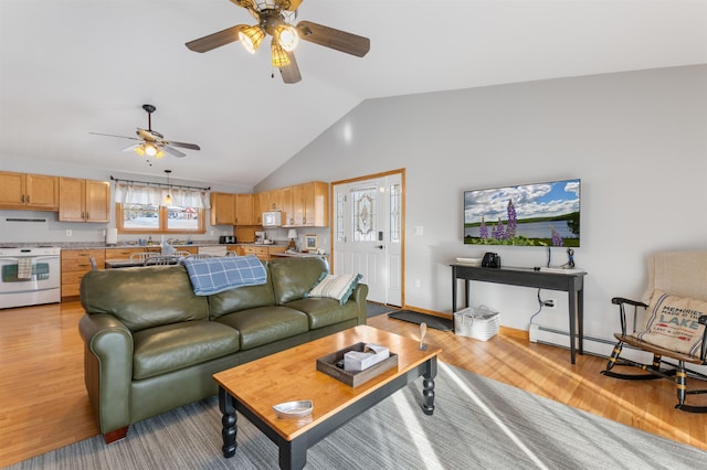 living room with lofted ceiling, light wood-type flooring, a ceiling fan, and baseboards