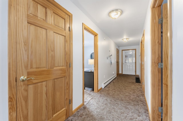 hallway featuring a baseboard radiator, baseboards, and light colored carpet