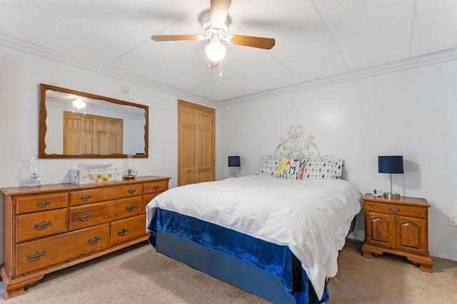 bedroom featuring light carpet, a closet, a ceiling fan, and crown molding