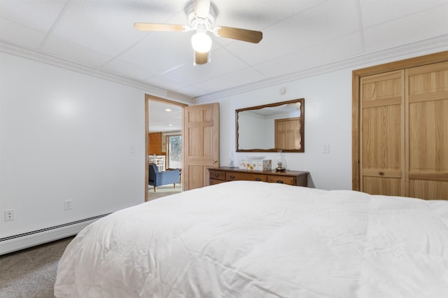 bedroom featuring ornamental molding, baseboard heating, carpet, and a ceiling fan