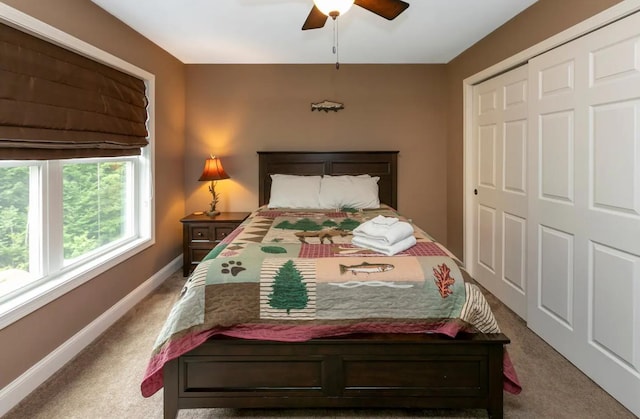 bedroom featuring carpet, baseboards, ceiling fan, and a closet