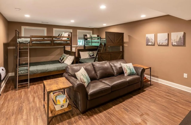 living room featuring baseboards, wood finished floors, and recessed lighting