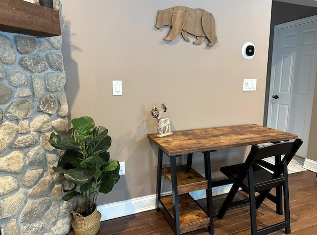 dining space featuring dark wood-style floors and baseboards