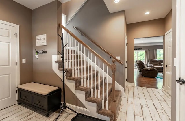 staircase featuring recessed lighting, baseboards, and wood finished floors