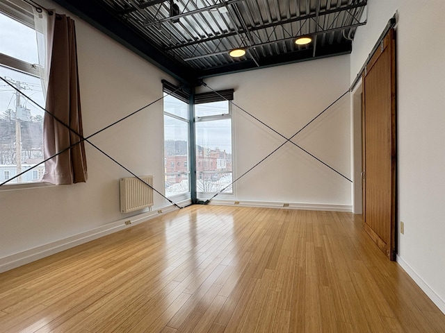 spare room featuring light wood-type flooring and baseboards