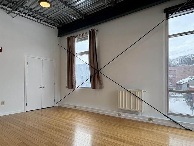 spare room with light wood finished floors, visible vents, and baseboards