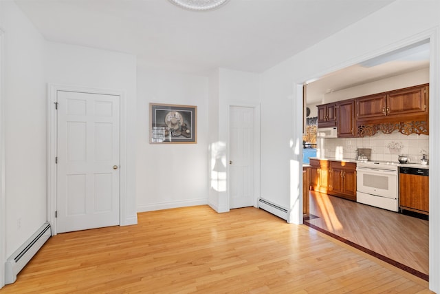 kitchen featuring white appliances, decorative backsplash, baseboard heating, and light countertops