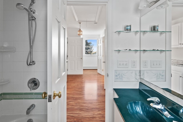 bathroom with vanity, tub / shower combination, wood finished floors, and a baseboard radiator