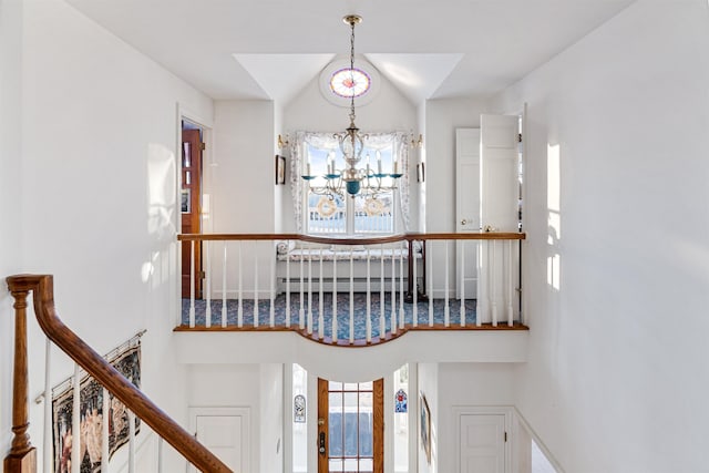 stairway with an inviting chandelier, a high ceiling, and baseboard heating