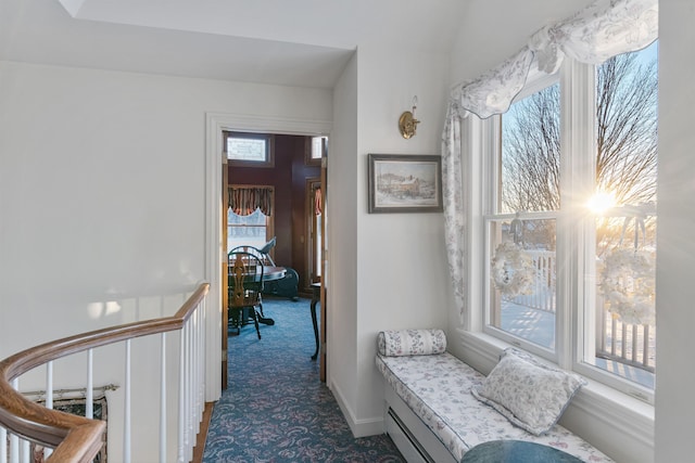 hall featuring dark carpet and baseboards