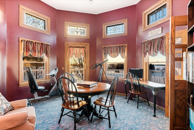 dining area featuring carpet floors, a high ceiling, and baseboards