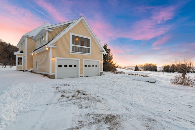 snow covered property featuring a garage