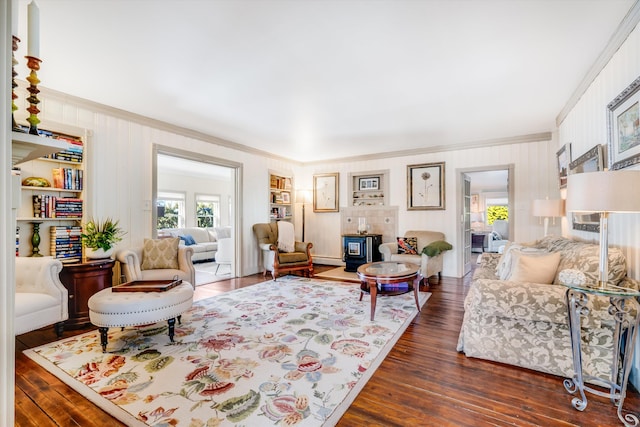 living area with a wood stove, crown molding, and dark wood-style flooring