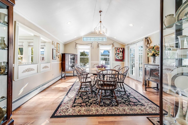 dining area with light wood-style flooring, ornamental molding, vaulted ceiling, french doors, and a chandelier