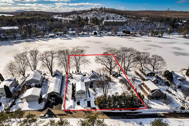 snowy aerial view with a mountain view and a residential view