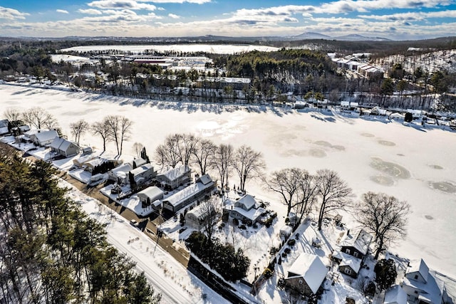 snowy aerial view featuring a residential view and a mountain view