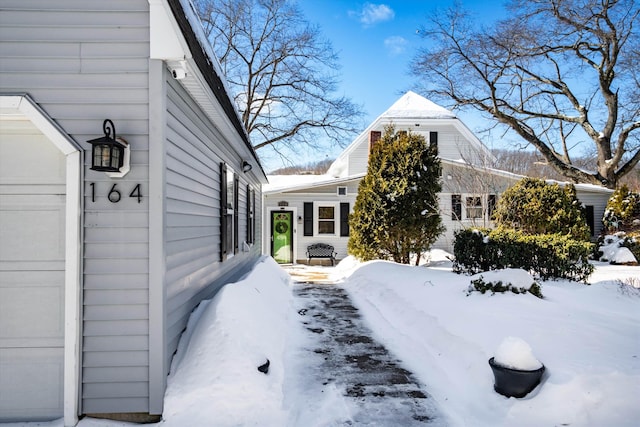 view of snow covered exterior with a garage