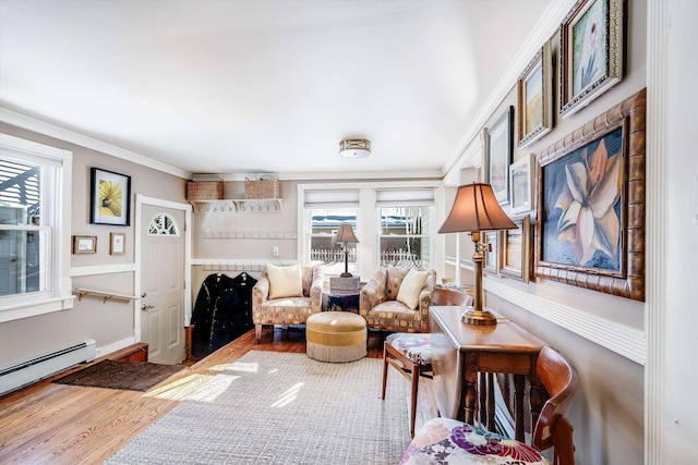 living area with ornamental molding, baseboard heating, and wood finished floors