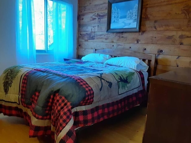 bedroom featuring wood walls and wood finished floors