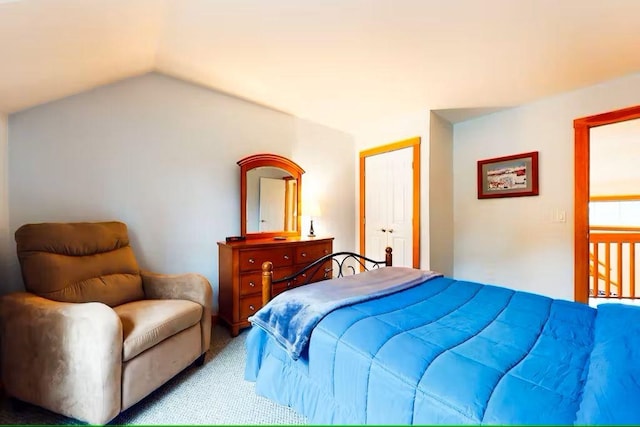 carpeted bedroom with lofted ceiling