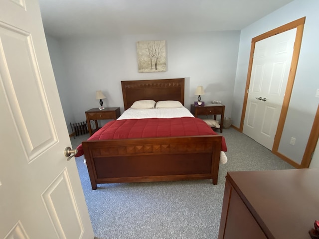 bedroom with baseboards and light colored carpet