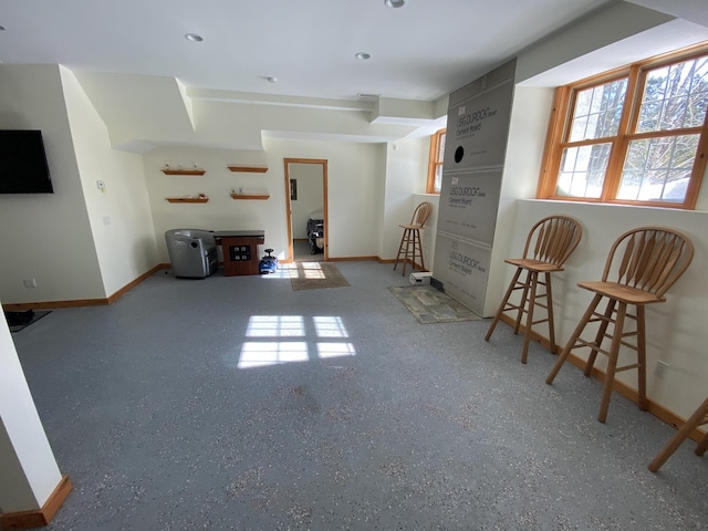 unfurnished living room with baseboards and speckled floor