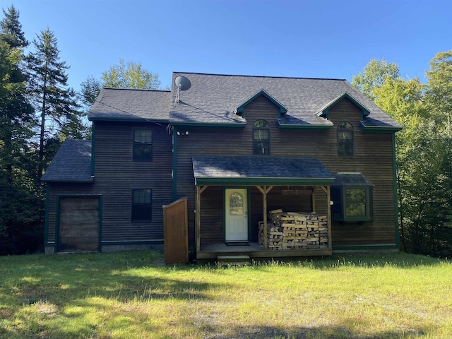 view of front facade with roof with shingles and a front yard