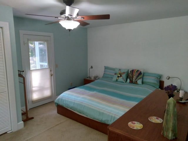 bedroom with light carpet and a ceiling fan