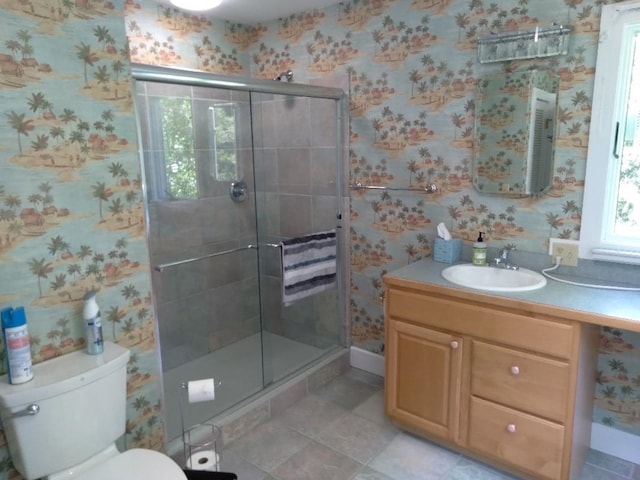 bathroom with a stall shower, vanity, toilet, and wallpapered walls