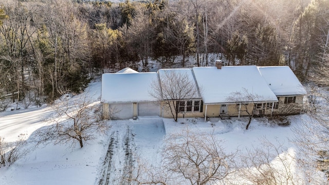 snowy aerial view featuring a forest view