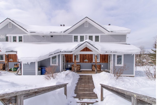 view of snow covered rear of property