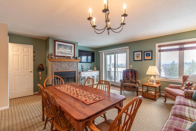 carpeted dining area featuring a chandelier, a textured ceiling, a tile fireplace, baseboards, and baseboard heating