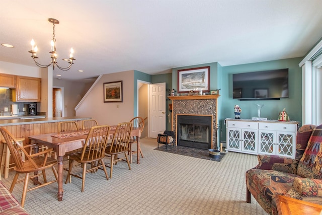 dining space featuring a tiled fireplace, light colored carpet, stairway, an inviting chandelier, and recessed lighting