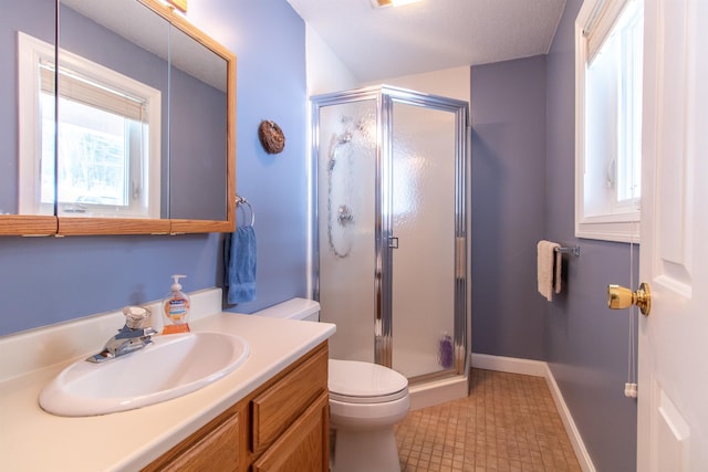 full bath featuring a stall shower, baseboards, vanity, and toilet