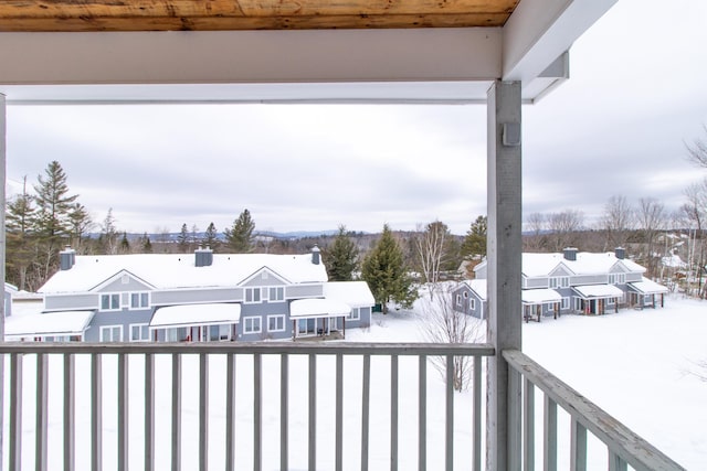 snow covered back of property featuring a residential view