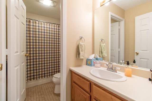 bathroom with toilet, tile patterned floors, a textured ceiling, and vanity