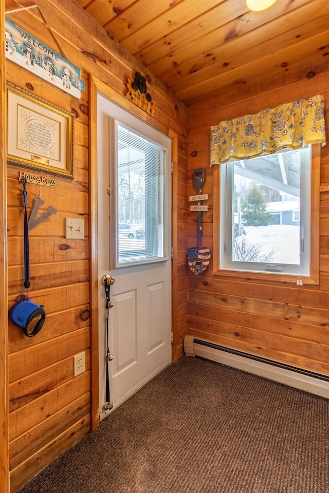 doorway with wooden ceiling, wooden walls, dark carpet, and baseboard heating