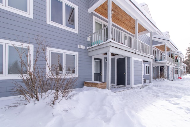 view of snow covered exterior featuring a balcony